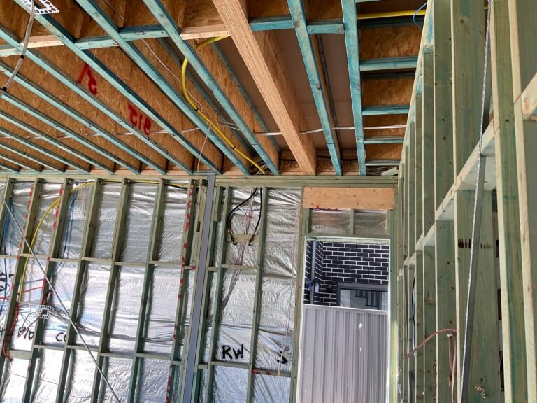 Building inspector checking floor joist installation during stage inspection in Sydney home.